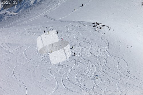 Image of Snowboarders and skiers downhill on off piste slope.