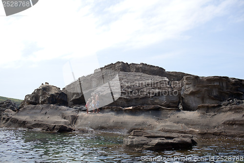 Image of Father and children on cliff