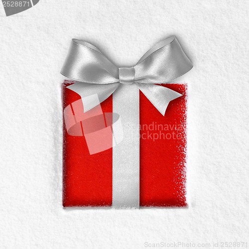 Image of gift with a bow on snow background