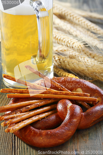 Image of Salted pretzel sticks and a beer.