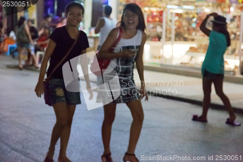 Image of PATONG, THAILAND - APRIL 26, 2012: girls walking in the evening 