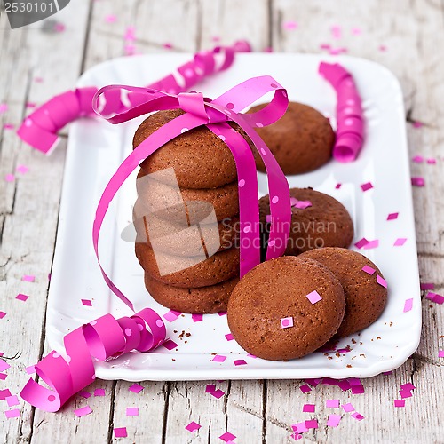 Image of plate of fresh chocolate cookies with pink ribbon and confetti 