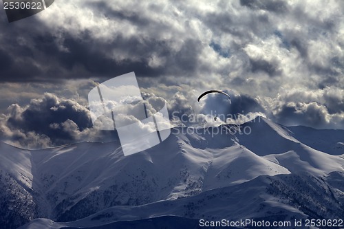 Image of Evening mountain with clouds and silhouette of parachutist