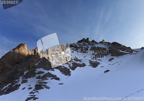 Image of Group of hikers on snowy slope in early morning