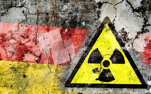 Image of Old cracked wall with radiation warning sign and painted flag