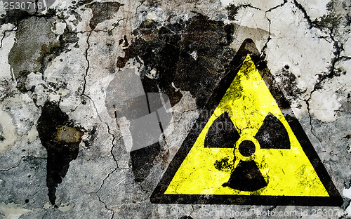 Image of Old cracked wall with radiation warning sign and painted flag