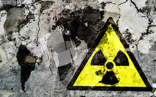 Image of Old cracked wall with radiation warning sign and painted flag