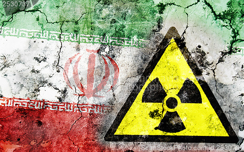 Image of Old cracked wall with radiation warning sign and painted flag