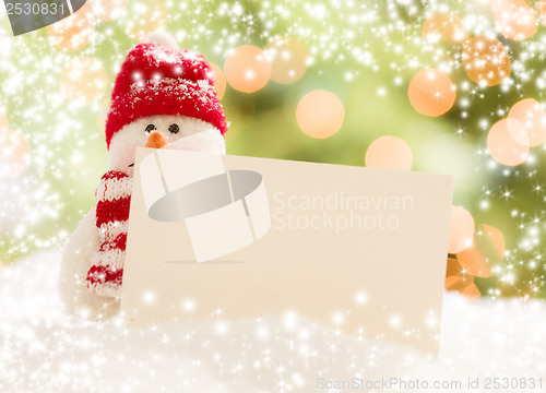 Image of Snowman with Blank White Card Over Abstract Snow and LIght