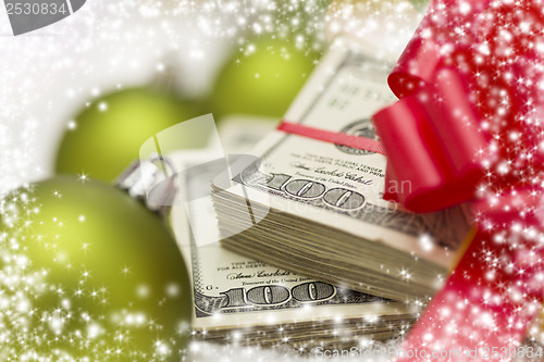 Image of Stack of Hundred Dollar Bills with Bow Near Christmas Ornaments