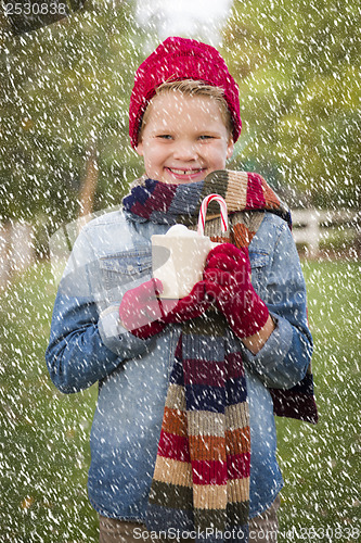 Image of Young Boy in Warm Clothing Holding Hot Cocoa Mug Outside