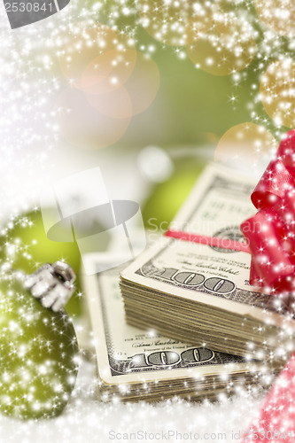 Image of Stack of Hundred Dollar Bills with Bow Near Christmas Ornaments
