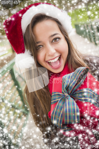 Image of Pretty Woman Wearing a Santa Hat with Wrapped Gift