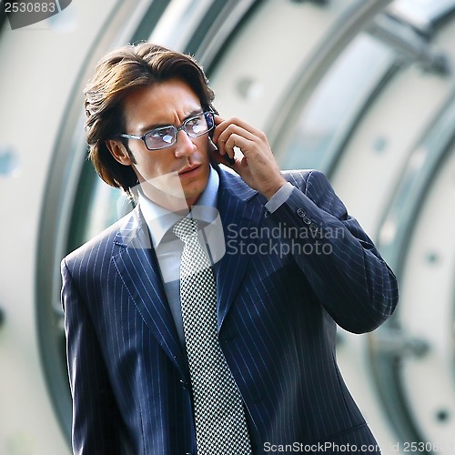 Image of talking on mobile phone in office lobby