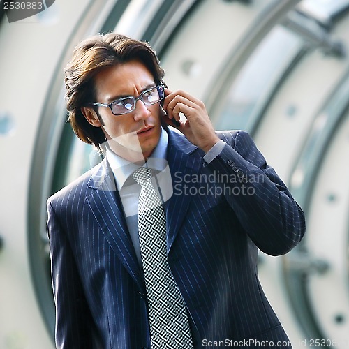 Image of talking on mobile phone in office lobby