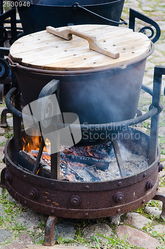 Image of old pot for cooking over a campfire, close-up. 