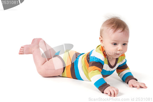 Image of Cute kid in a striped body lying on his tummy