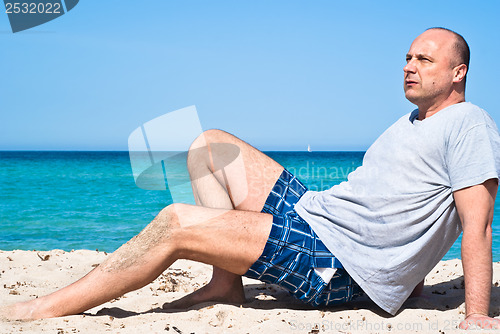 Image of man sitting on the beach to relax