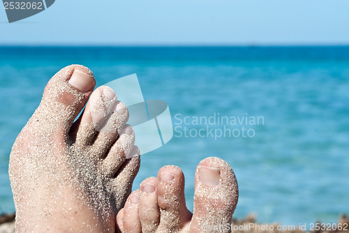 Image of male feet on the beach