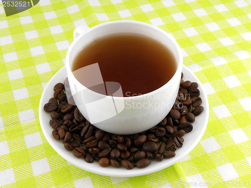 Image of Cup of coffee with coffee beans on a beautiful yellow background