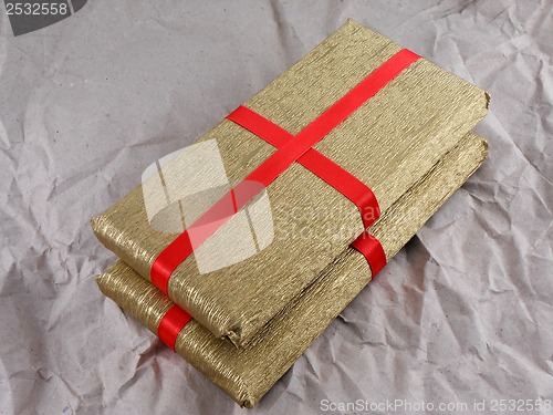 Image of golden gift box with red bow on vintage grunge paper