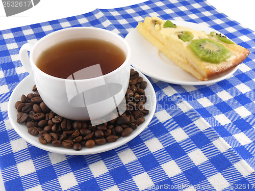 Image of A cup of coffee and a piece of tasty creamy cake with coffee beans