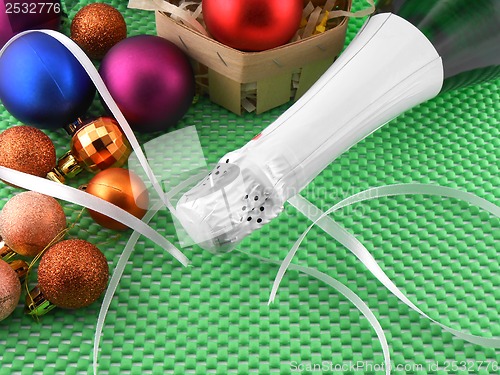 Image of Bottle of champagne and Christmas balls on green background
