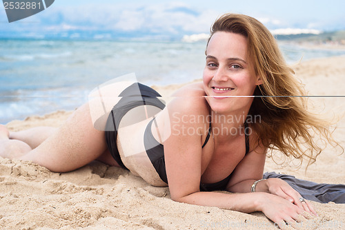 Image of Beautiful woman in swimsuit relaxing on a beach