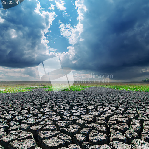 Image of global warming. cracked earth and dark clouds