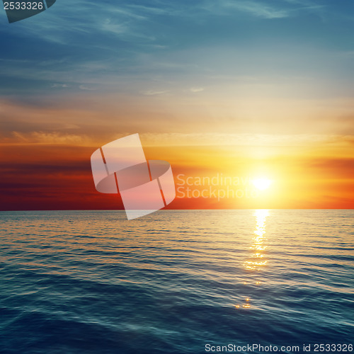 Image of good red sunset over darken sea