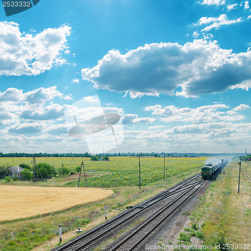 Image of old train on railroad under cloudy sky