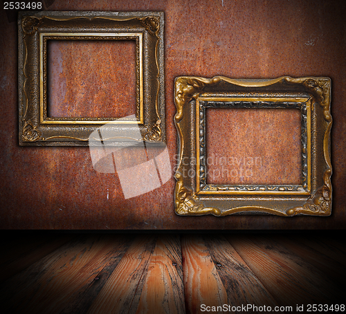Image of empty painting frames on rusted wall