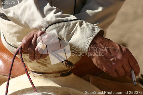 Image of Hands of cowboy with cigarette