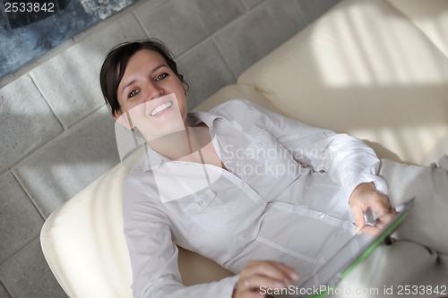 Image of woman reading magazine at home