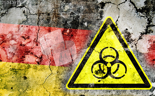 Image of Old cracked wall with biohazard warning sign and painted flag