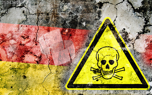 Image of Old cracked wall with poison warning sign and painted flag