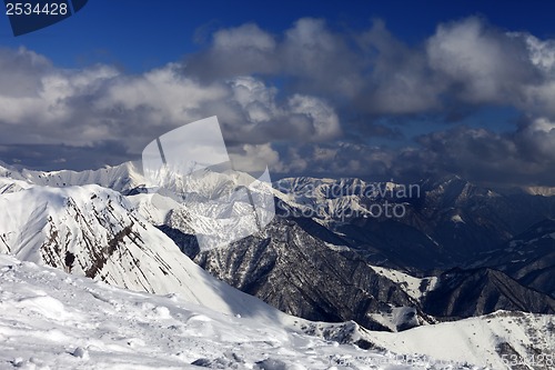 Image of Winter sunlit mountains in clouds