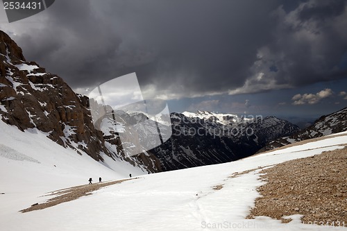 Image of Group of hikers in snowy mountains before storm