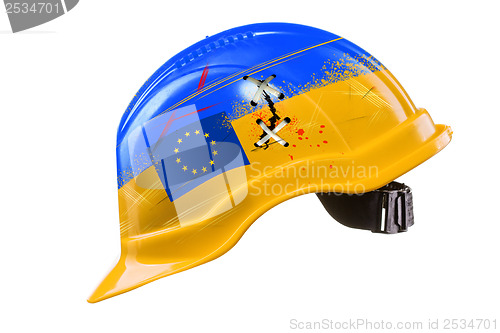 Image of Blue and yellow hard hat with cracks, scratches and EU flag. KIE