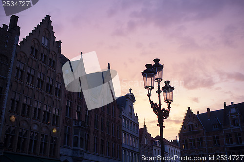 Image of Silhouettes of city center houses in Bruges against beautiful su