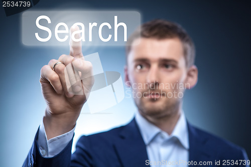 Image of business man pressing Search button on touchscreen