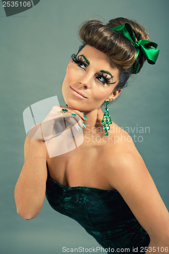 Image of brunette woman with green jewelery and accssesoires