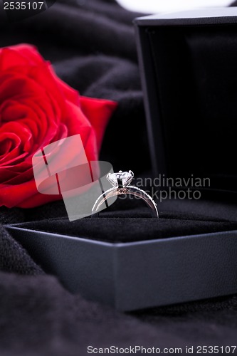 Image of red rose and diamond ring in a box 