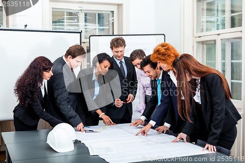 Image of business people discussing architecture plan sketch 