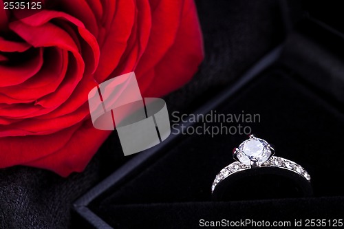 Image of red rose and diamond ring in a box 