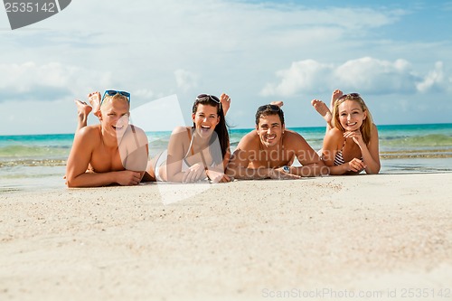 Image of young happy friends havin fun on the beach