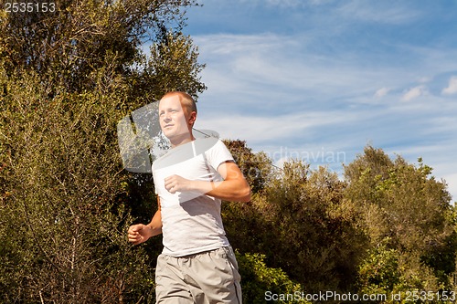 Image of athletic man runner jogging in nature outdoor