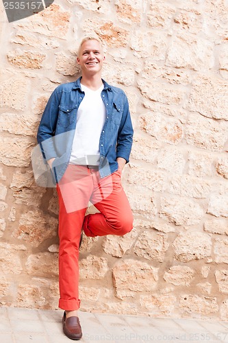 Image of attractive young adult man standing outside 