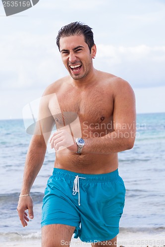 Image of attractive young athletic man on the beach