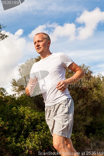 Image of athletic man runner jogging in nature outdoor